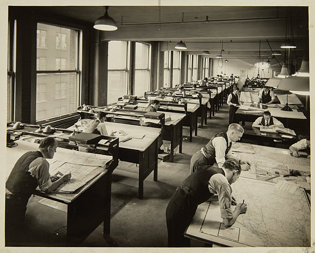 A group of men drafting maps by hand